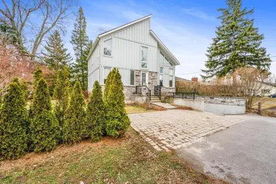 a white house with trees in front of it at Beautiful 3BR Old Town Home Steps to Queen St in Niagara on the Lake
