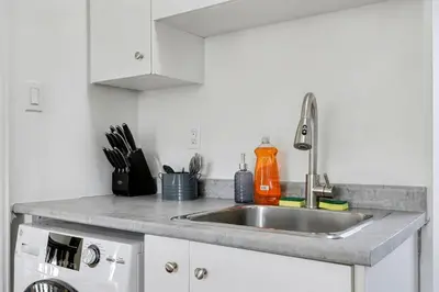 a kitchen counter with a sink and a stove at 1 Bed Suite Steps to Bloor in Toronto
