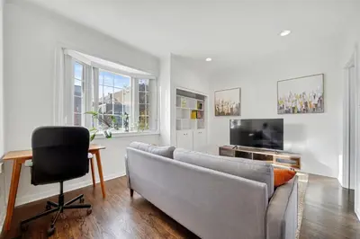 a living room with a couch and a chair and a television at 1 Bed Suite Steps to Bloor in Toronto