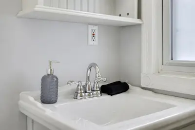 a white sink with a soap dispenser on top of it at 1 Bed Suite Steps to Bloor in Toronto