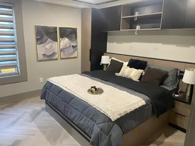 a bedroom with a large bed in a room at Modern 4 Bedroom Ground Floor Bungalow Style Home in Niagara Falls
