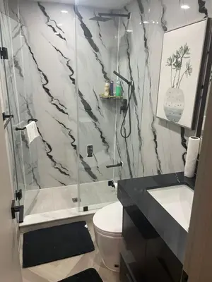 a bathroom with a shower and a toilet and a sink at Modern 4 Bedroom Ground Floor Bungalow Style Home in Niagara Falls