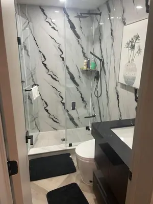 a bathroom with a shower and a toilet and a sink at Modern 4 Bedroom Ground Floor Bungalow Style Home in Niagara Falls