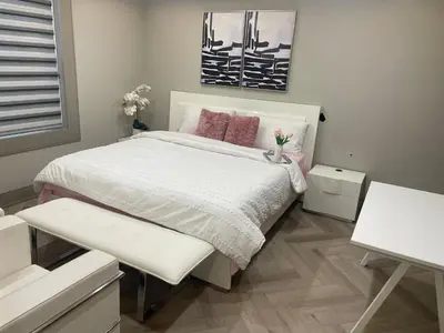 a bedroom with a large bed with pink pillows at Modern 4 Bedroom Ground Floor Bungalow Style Home in Niagara Falls