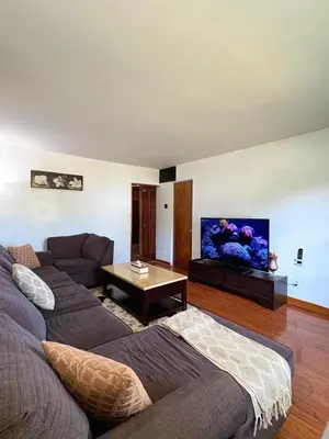 a living room with a couch and a flat screen tv at Cozy 3BR House Near Airport & Transit! in Mississauga