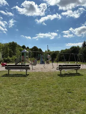 two benches in a park with a playground at Cozy 3BR House Near Airport & Transit! in Mississauga