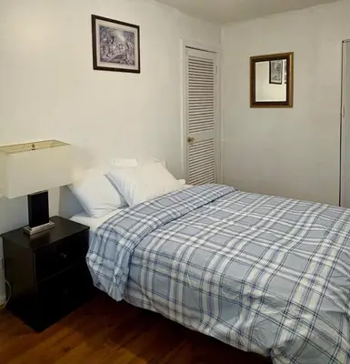 a bedroom with a bed with a blue and white plaid blanket at Cozy 3BR House Near Airport & Transit! in Mississauga