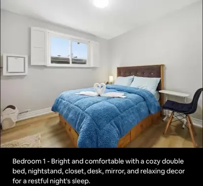 a bedroom with a bed with a blue blanket and a desk at Renovated 4-Bedroom Upper-Unit Detached House 5 Beds Near Toronto Pearson Airport in Toronto
