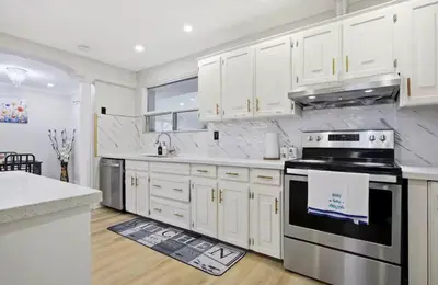 a kitchen with white cabinets and a stove top oven at Renovated 4-Bedroom Upper-Unit Detached House 5 Beds Near Toronto Pearson Airport in Toronto
