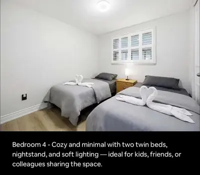 two beds in a room with two towels on them at Renovated 4-Bedroom Upper-Unit Detached House 5 Beds Near Toronto Pearson Airport in Toronto