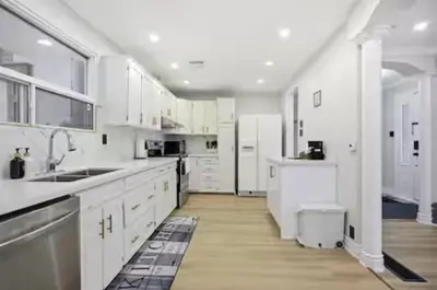 a white kitchen with white cabinets and a sink at Renovated 4-Bedroom Upper-Unit Detached House 5 Beds Near Toronto Pearson Airport in Toronto