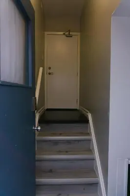 a hallway with stairs leading to a door at Modern 3 Bedroom Guest Suite in Toronto