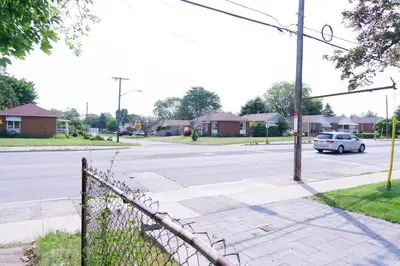 a street with a white car driving down the street at Modern 3 Bedroom Guest Suite in Toronto