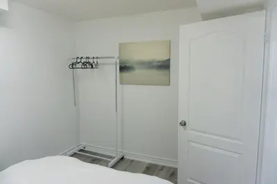 a white bedroom with a shower and a bed at Modern 3 Bedroom Guest Suite in Toronto