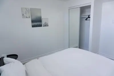a white room with a bed and a closet at Modern 3 Bedroom Guest Suite in Toronto