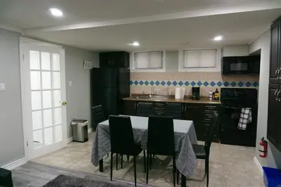 a kitchen with a table and chairs in a room at Modern 3 Bedroom Guest Suite in Toronto