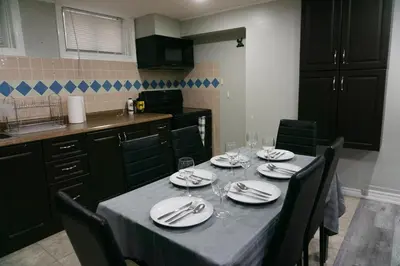 a dining room table with plates and wine glasses at Modern 3 Bedroom Guest Suite in Toronto