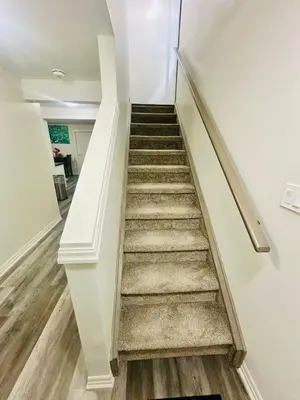 a staircase in a home with white walls and wooden floors at Sky Cove - Modern Comfort, Simple, Cozy, Central in Saint Thomas
