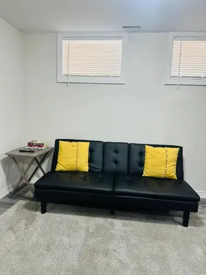a black couch with two yellow pillows in a room at Sky Cove - Modern Comfort, Simple, Cozy, Central in Saint Thomas