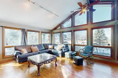 a living room with a couch and chairs and windows at Main House in Wasaga Beach