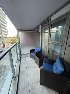 a balcony with couches and chairs on a building at Condo in the heart of toronto in Toronto