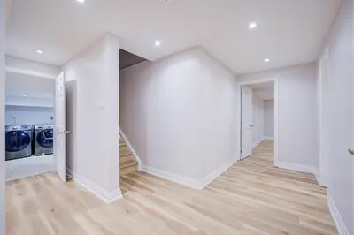 an empty living room with white walls and wood floors at Vantage stay Stouffville 4BR Bright Home in Stouffville