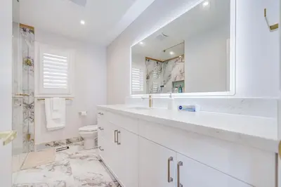 a white bathroom with a sink and a toilet at Vantage stay Stouffville 4BR Bright Home in Stouffville