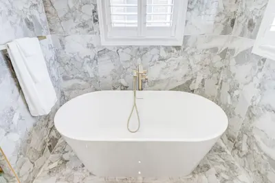 a white bath tub in a bathroom with marble walls at Vantage stay Stouffville 4BR Bright Home in Stouffville