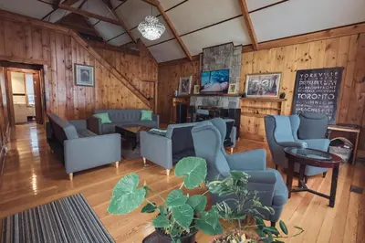 a living room with blue chairs and a chalkboard at Beach Front Family Cottage Ping Pong & Karaoke in Fort Erie
