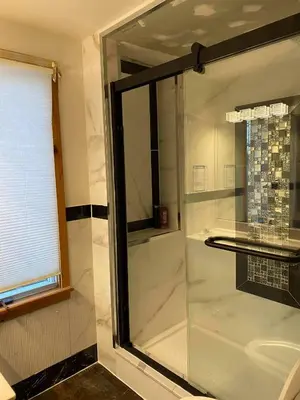 a shower with a glass door in a bathroom at Beach Front Family Cottage Ping Pong & Karaoke in Fort Erie