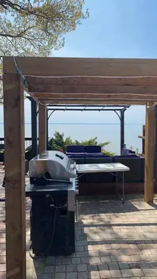 a grill under a pavilion on a patio at Beach Front Family Cottage Ping Pong & Karaoke in Fort Erie