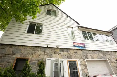 a white house with a stone at Beach Front Family Cottage Ping Pong & Karaoke in Fort Erie