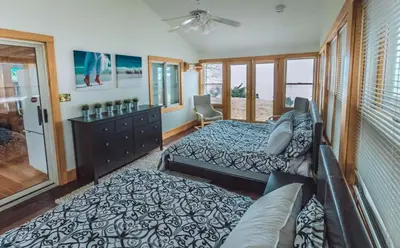 a bedroom with two beds and a couch at Beach Front Family Cottage Ping Pong & Karaoke in Fort Erie