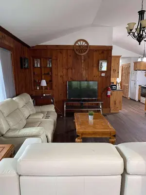 a living room with white furniture and a flat screen tv at Cottage on Crystal Beach 3BR & BBQ in Fort Erie