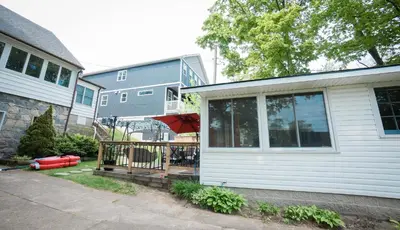 a house with a deck with an umbrella on it at Cottage on Crystal Beach 3BR & BBQ in Fort Erie