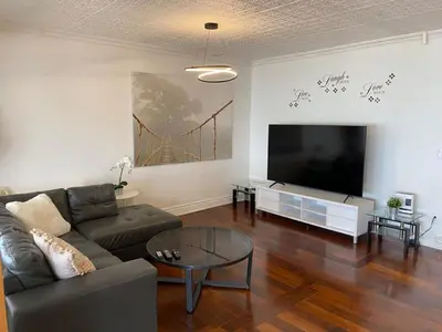 a living room with a couch and a flat screen tv at Water Front Beach House - 3BR w BBQ & Sunset in Fort Erie