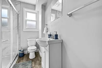 a white bathroom with a toilet and a sink at NEW 5 Bedroom House Near The Falls in Niagara Falls