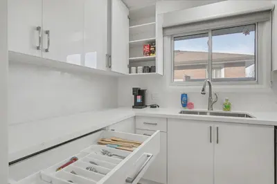 a white kitchen with white cabinets and a sink at New 3BR Home - Minutes to the Falls in Niagara Falls