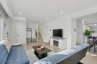 a living room with a blue couch and a table at New 3BR Home - Minutes to the Falls in Niagara Falls