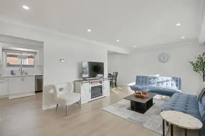 a living room with a blue couch and a tv at New 3BR Home - Minutes to the Falls in Niagara Falls