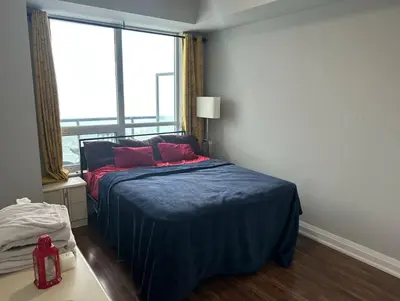 a bedroom with a bed with red pillows and a window at Entire Place With Pool Sauna in Vaughan
