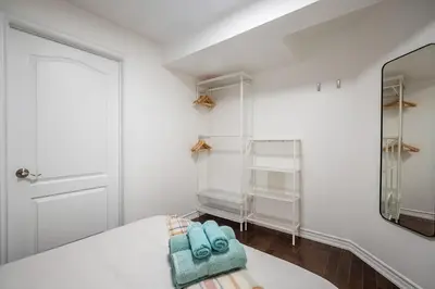a white room with a mirror and a bed at Basement Suite for 2 w Private Patio in Toronto in Toronto