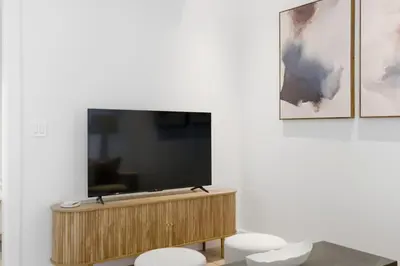 a flat screen tv sitting on top of a wooden cabinet at The Brick Hotel - The Laneway in Toronto