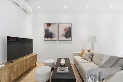 a living room with a couch and a tv at The Brick Hotel - The Laneway in Toronto