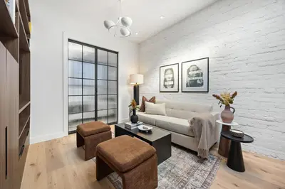 a living room with a white brick wall at The Brick Hotel - The Loft in Toronto