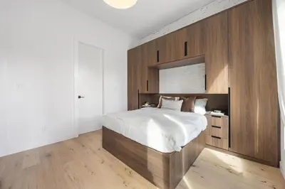 a bedroom with a large bed with a wooden wall at The Brick Hotel - The Loft in Toronto
