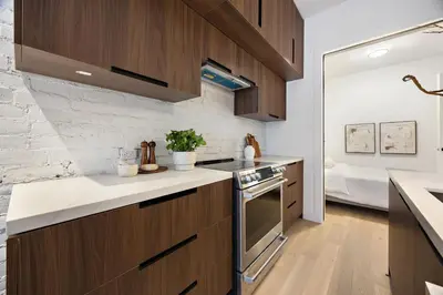 a kitchen with wooden cabinets and a counter top at The Brick Hotel - The Second Suite in Toronto