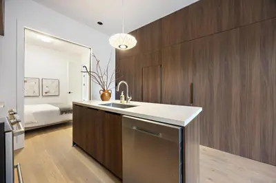 a kitchen with a sink and wooden cabinets at The Brick Hotel - The Second Suite in Toronto