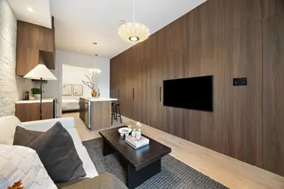 a living room with a couch and a tv on a wall at The Brick Hotel - The Second Suite in Toronto