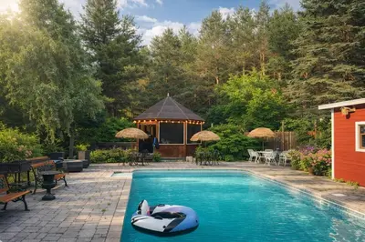 a pool with a swan float in front of a gazebo at Luxury Forest Retreat Near Mansfield Ski Club in Mulmur